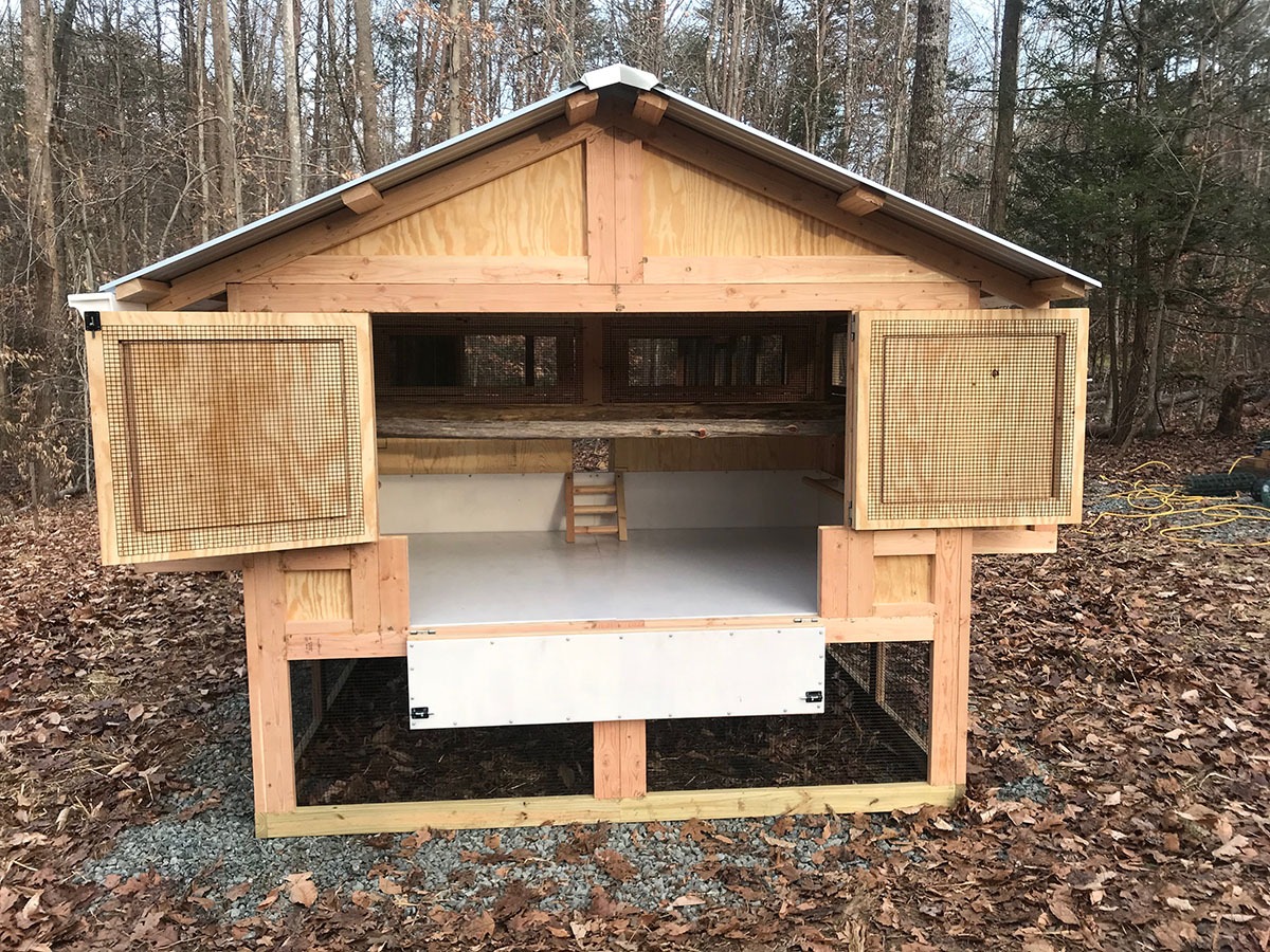 Back of the 6’x8′ henhouse of an 8’x24′ American Coop with natural tree branch roost bars